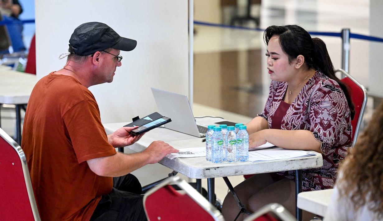 Gede Eka Sandi Asmadi menambahkan, berdasar data dari maskapai penerbangan, calon penumpang dari penerbangan yang mengalami penyesuaian jadwal tersebut berjumlah 3.197 penumpang. Tampak dalam foto, seorang penumpang berbicara dengan staf bandara di tengah gangguan penerbangan akibat serangan Israel-Amerika Serikat terhadap Iran, di Bandara Internasional I Gusti Ngurah Rai, Bali, pada Senin 2 Maret 2026. (SONNY TUMBELAKA/AFP)