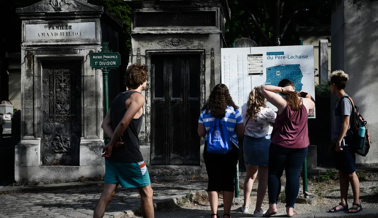 Turis melihat peta pemakaman Pere Lachaise sebelum memulai kunjungan mereka di Paris (22/7/2019). Pemakaman Père adalah salah satu pemakaman terbesar di Paris (luasnya sekitar 44 hektar 110 acre). (AFP Photo/Philippe Lopez)