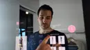  Peneliti Oak Labs, Wesley Bliss saat menggunakan cermin pintar Oak Fitting Room di sebuah butik, New York, AS (7/2). Cermin yang dilengkapi dengan teknologi RFID ini mampu mendeteksi baju yang dibawa pembeli. (AFP Photo / Jewel Samad)