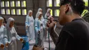 Peningkatan pesanan terjadi sejak beberapa bulan lalu. Tampak dalam foto, seorang pekerja menyemprotkan cat ke patung-patung keagamaan Kristen di bengkel kerajinan Studio Malta Jaya di Bantul, Yogyakarta, pada Kamis 18 Desember 2025. (DEVI RAHMAN/AFP)