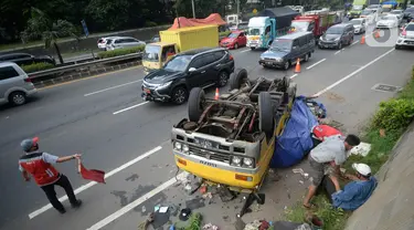 Truk bermuatan puing terbalik akibat salah satu ban belakang lepas di jalan tol Pondok Indah dekat pintu keluar Lebak Bulus, Jakarta, Jumat (29/5/2020). Dalam kecelakaan tersebut tidak ada korban jiwa namun membuat kendaraan yang melintas jalan tol tersendat. (merdeka.com/Dwi Narwoko)