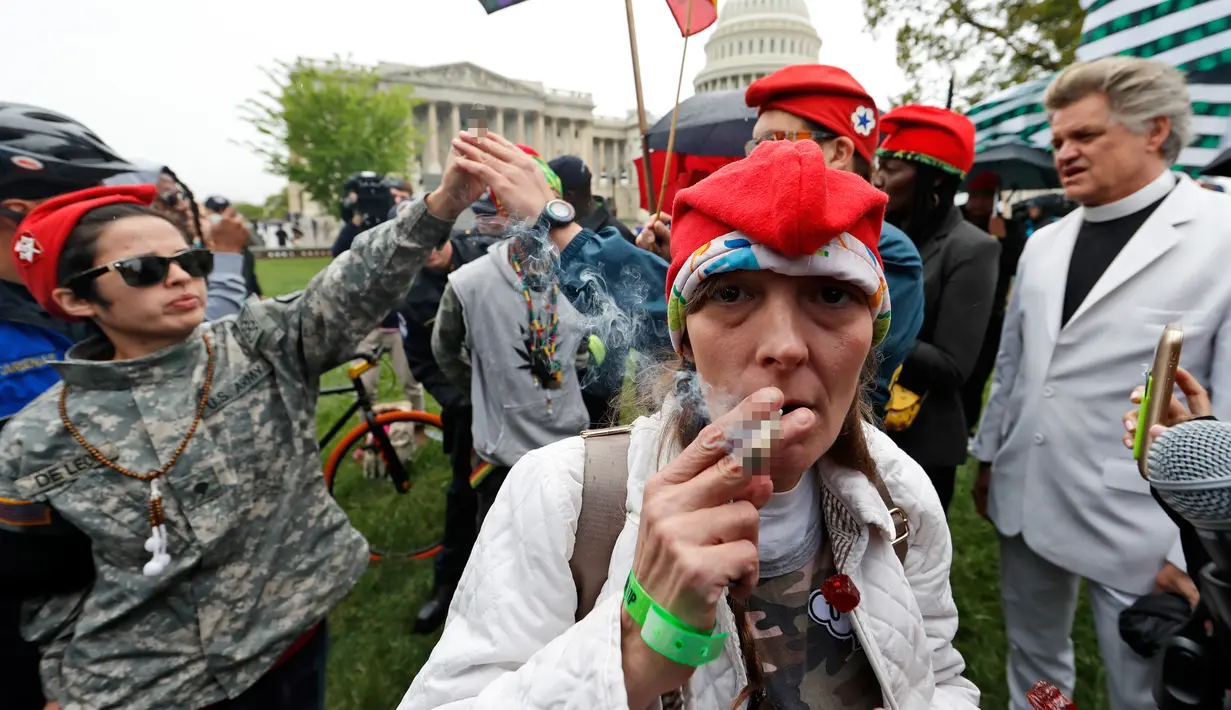 Rachel Ramone Donlan menghisap ganja saat menggelar aksi di dekat gedung Capitol di Washington (24/4). Sebelumnya para aktivis ganja ini merencanakan untuk mendistribusikan tempat gratis bagi para staf kongres di Capitol Hill. (AP Photo/Alex Brandon)