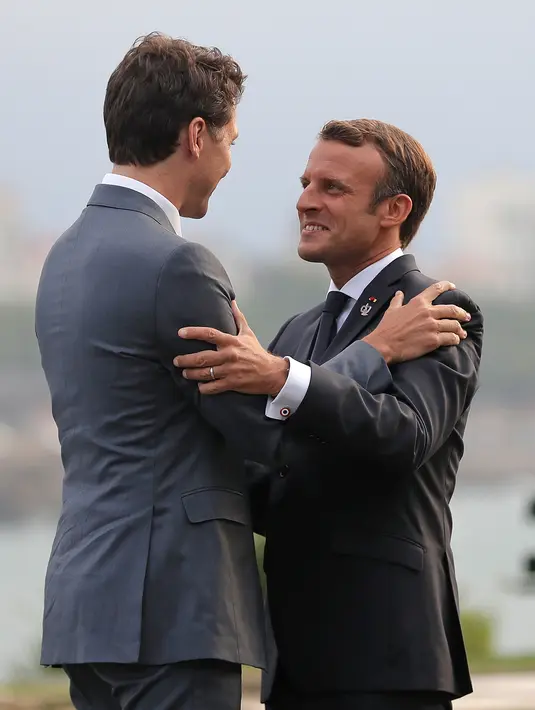 Presiden Prancis Emmanuel Macron (kanan) memeluk Perdana Menteri Kanada Justin Trudeau saat menyambut kedatangannya di KTT G7, Biarritz, Prancis, Sabtu (24/8/2019). Negara-negara G7 mewakili lebih dari 64 persen kekayaan bersih global. (AP Photo/Markus Schreiber)