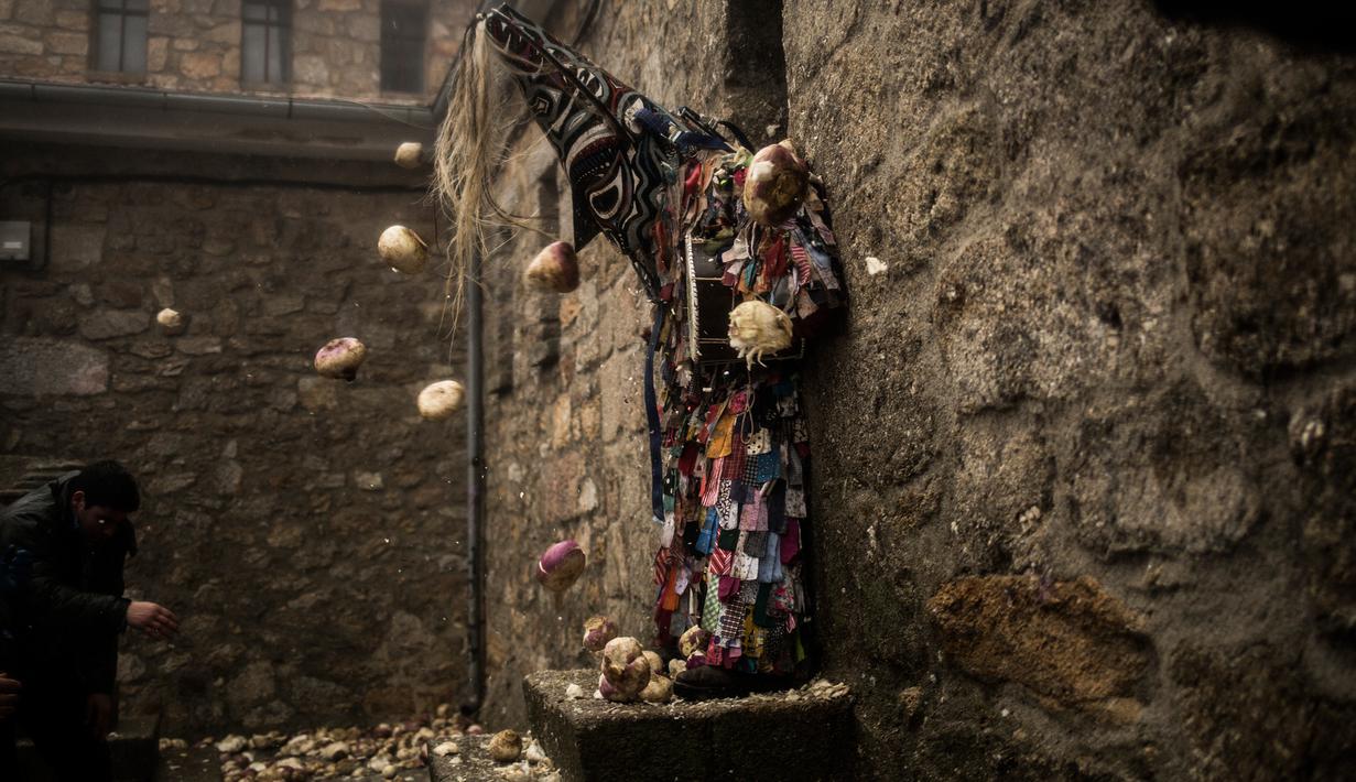 Orang-orang melempari seorang pria berkostum ala setan dengan sayuran lobak selama Festival Jarramplas di kota Piornal, Spanyol, Sabtu (19/1). Acara tahunan ini berlangsung setiap 19-20 Januari pada Saint Sebastian Day. (AP/Javier Fergo)