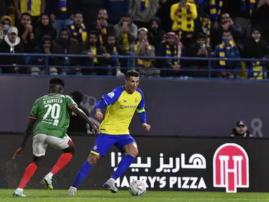 Cristiano Ronaldo dari Al Nassr (kanan) berusaha melewati pemain Al Ettifaq, Abdallah Khateeb selama pertandingan Liga Pro Saudi di Stadion Mrsool Park, di Riyadh, Arab Saudi, Minggu (22/1/2023). Al Nassr menang tipis atas Ettifaq dengan skor 1-0. (AP Photo)