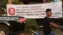 Pengendara motor melintasi spanduk penolakan lokasi penampungan pencari suaka di Kalideres, Jakarta, Selasa (16/7/2019). Sejak Kamis (11/7) para pencari suaka dipindahkan dari di pinggir jalan dan trotoar di kawasan Kebon Sirih ke bekas Markas Kodim di Kalideres . (Liputan6.com/Helmi Fithriansyah)