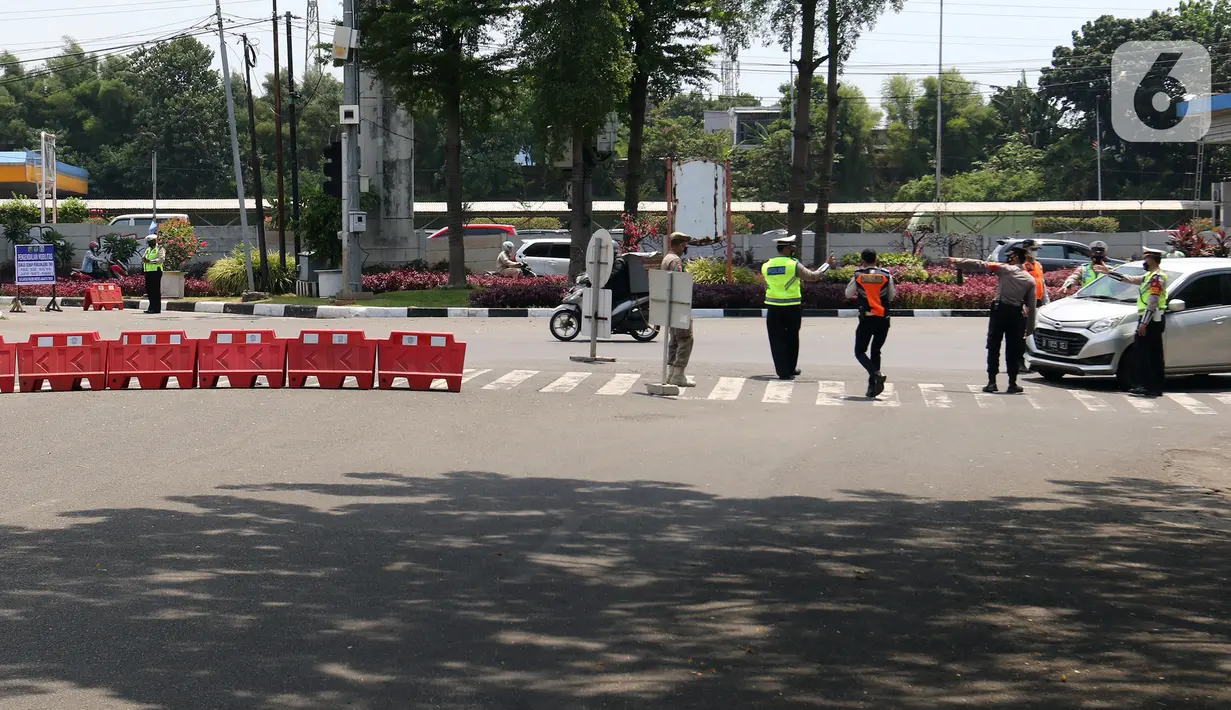 Polisi mengatur lalu lintas saat pengendalian mobilitas ganjil genap untuk pengunjung TMII di Jalan Pintu 1 TMII, Jakarta, Sabtu (18/9/2021). Polda Metro Jaya memberlakukan pembatasan mobilitas warga dengan sistem ganjil genap pada TMII dan Taman Impian Jaya Ancol. (Liputan6.com/Herman Zakharia)