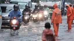 Petugas PPSU mengatur lajur kendaraan saat banjir menggenangi Jalan DI Panjaitan, Jakarta, Senin (3/12). Banjir juga disebabkan adanya pengerjaan proyek Tol Becakayu yang berada di jalan tersebut. (Merdeka.com/ Iqbal S. Nugroho)