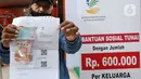 Keluarga Penerima Manfaat (KPM) mencairkan bantuan sosial tunai di Kantor Pos Bogor, Jawa Barat, Rabu (13/5/2020). Bantuan bagi yang terdampak COVID-19 tersebut berupa bantuan langsung tunai senilai Rp 600 ribu per bulan selama tiga bulan ke depan. (merdeka.com/Arie Basuki)