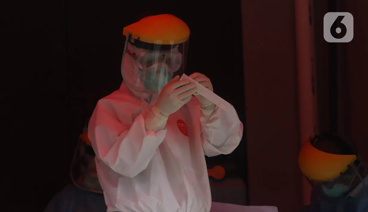 Petugas mengamati alat swab spesimen saat swab test di halaman Laboratorium Kesehataan Daerah (LABKESDA) Kota Tangerang, Banten, Kamis (9/4/2020). Pemerintah Kota Tangerang melaksanakan swab test yang dilakukan untuk tenaga medis dan orang dalam pemantauan (ODP). (Liputan6.com/Angga Yuniar)