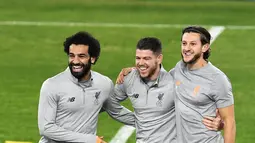 Penyerang Liverpool, Mohamed Salah (kiri) tertawa dengan rekan setimnya Alberto Moreno (tengah) dan Adam Lallana saat mengikuti latihan jelang menghadapi Sevilla di stadion Ramon Sanchez Pizjuan di Sevilla, Spanyol (20/11). (AFP Photo/Cristina Quicler)