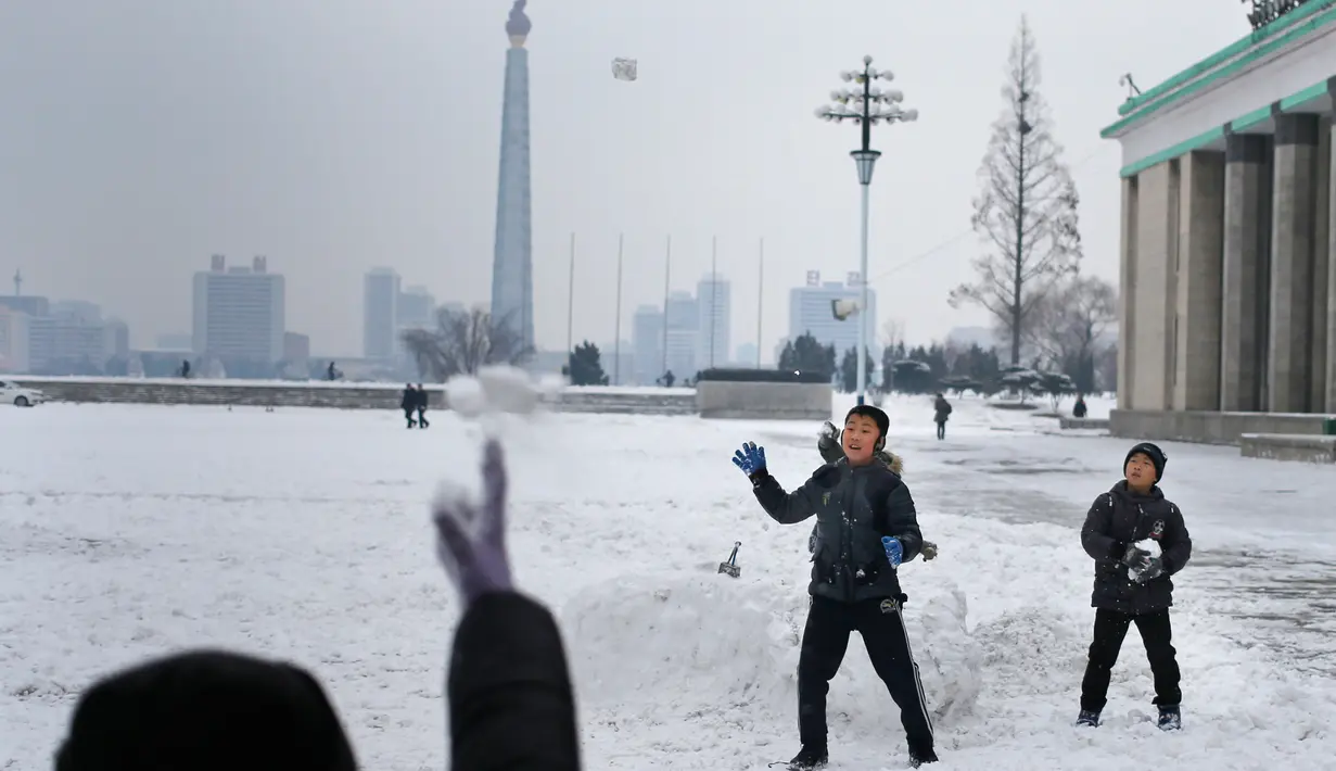 Anak-anak bermain bola salju di Kim Il Sung Square, di Pyongyang, Korea Utara Minggu (16/12). Korea Utara saat ini mulai memasuki musim dingin. (AP Photo/Dita Alangkara)