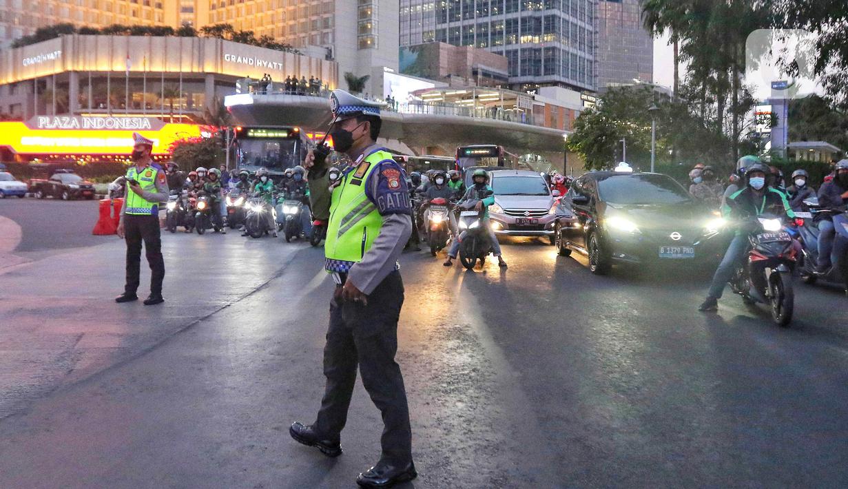 Petugas kepolisian melakukan giat buka tutup arus lalu lintas di kawasan Bundaran Hotel Indonesia, Jakarta, Senin (4/9/2023). (Liputan6.com/Angga Yuniar)