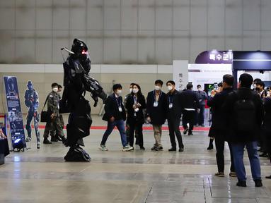 Pengunjung mengamati sebuah robot prajurit dalam Pameran Pertahanan dan Keamanan Korea Selatan  2020 di Korea International Exhibition Center di Goyang, Korea Selatan (18/11/2020). Korsel memutuskan untuk menaikkan satu level dari lima tingkat aturan social distancing. (Xinhua/Wang Jingqiang)