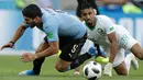 Penyerang Uruguay, Luis Suarez dan pemain Arab Saudi Salem Aldawsari terjatuh saat berebut bola pada pertandingan kedua Grup A Piala Dunia 2018 di Rostov Arena, Rabu (20/6). Uruguay mengalahkan Arab Saudi 1-0 berkat gol Suarez. (AP/Andrew Medichini)