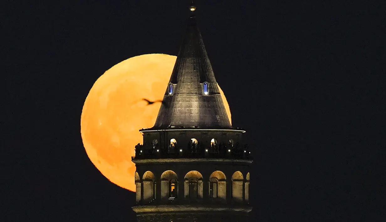 Bulan purnama terbesar atau supermoon muncul di belakang Menara Galata di Istanbul, Turki, Senin, 19 Agustus 2024. (AP Photo/Khalil Hamra)