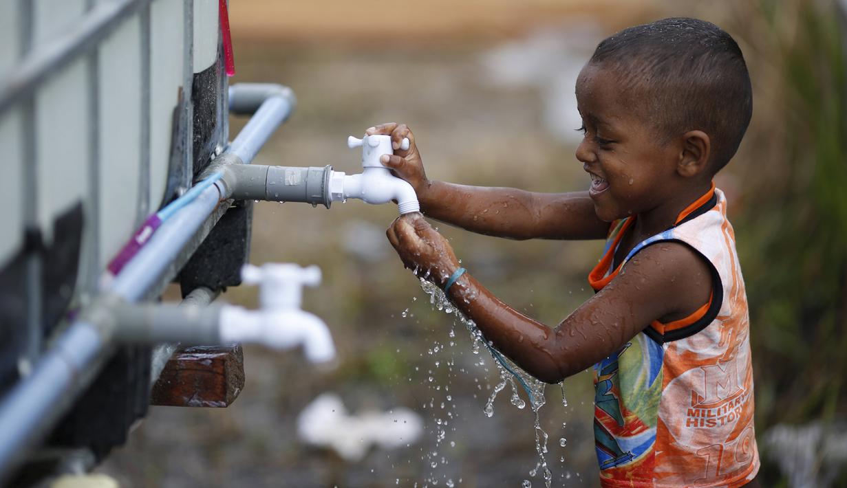 Seorang anak saat etnis Rohingya mengambil air di tempat penampungan, Kuala Langsa, Aceh (25/5/2015). Berdasarkan data pemerintah, pengungsi Rohingya dan Bangladesh yang berada di Aceh jumlahnya 1.759 orang. (Reuters/Nyimas Laula)