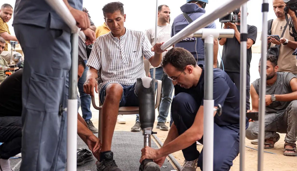 Seorang pria yang mengalami amputasi di atas lutut dipasangi kaki palsu di rumah sakit lapangan Yordania di Khan Yunis di Jalur Gaza selatan pada 17 September 2024. (Bashar TALEB/AFP)