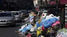 Kendaraan melintas di samping tumpukan sampah di sepanjang sisi jalan di Tripoli, ibukota Libya (30/9/2019). Berton-ton sampah berserakan dari tempat sampah dan menumpuk di pinggir jalan. (AFP Photo/Mahmud Turkia)