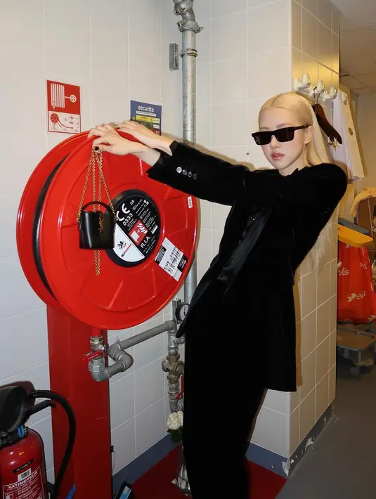 Ia pun menjinjing tas mini berantai emas dengan kacamata hitam. Sapu tangan putih satin jadi sentuhan kontras penampilan Rose. [@roses_are_rosie]