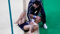 Atlet senam artistik Prancis, Samir Ait Said dibantu tim medis menutup matanya saat tergeletak di lantai dengan posisi kaki patah saat berlaga di Olimpiade Rio 2016 di Rio Olympic Arena, Brasil, Minggu (7/8). (REUTERS/Damir Sagolj)