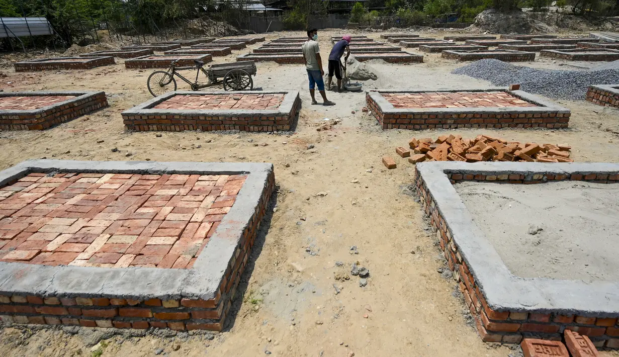 Para buruh bekerja membangun tempat kremasi di ladang kosong di New Delhi, India, Rabu (5/5/2021). Kasus COVID-19 di India terbanyak berada di negara bagian Maharashtra dengan 4,7 juta kasus. (Money SHARMA/AFP)