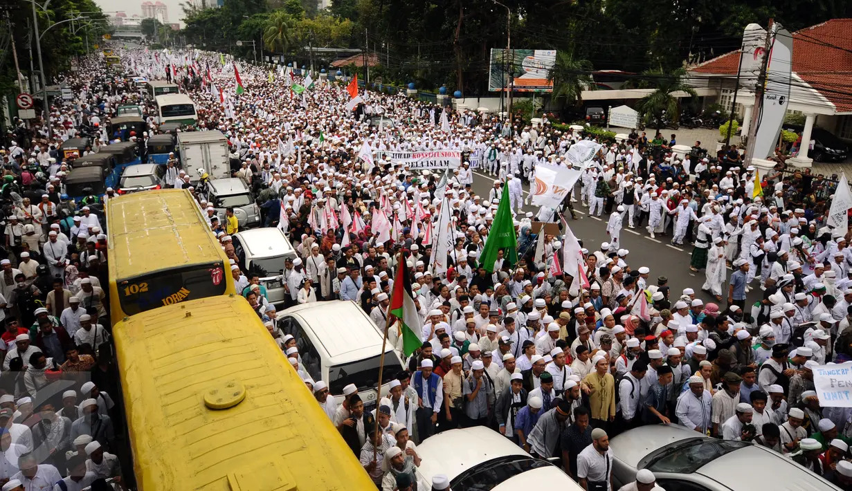 Ribuan Umat muslim  membentangkan spanduk dan mengibarkan bendera saat melakukan aksi menuju Balai Kota Jakarta, Jumat (14/10). Mereka mendesak Gubernur DKI Jakarta, Basuki Tjahaja Purnama mundur. (Liputan6.com/Hemi Fithriansyah)