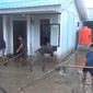 Warga penghuni hunian penyintas Gempa Palu membersihkan rumah mereka usai banjir, Minggu (31/7/2022). (Foto: Heri Susanto/ Liputan6.com).