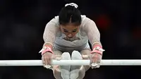 Pesenam asal Indonesia, Rifda Irfanaluthfi, menyelesaikan nomor uneven bars dalam babak kualifikasi cabor senam putri di Olimpiade 2024 di Bercy Arena, Paris, Minggu (28/7/2024). (Lionel BONAVENTURE / AFP)