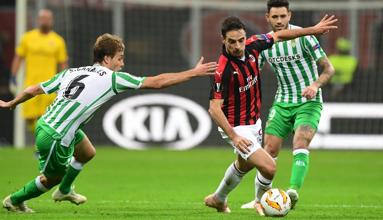 Gelandang AC Milan, Giacomo Bonaventura, berusaha melewati pemain Real Betis pada laga Liga Europa di Stadion San Siro, Kamis (25/10/2018). AC Milan takluk 1-2 dari Real Betis. (AFP/Miguel Medina)