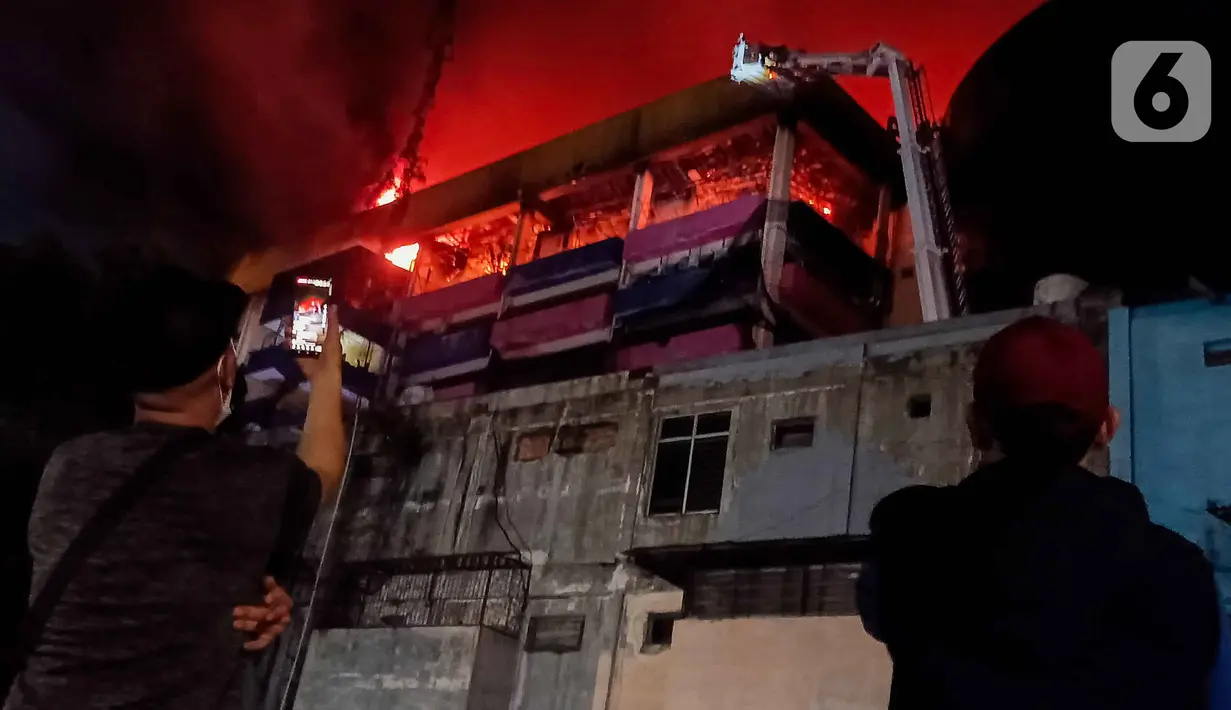 Warga merekam suasana kebakaran yang melanda pertokoan Glodok Plaza, Jakarta, Rabu (15/1/2025). (Liputan6.com/Herman Zakharia)