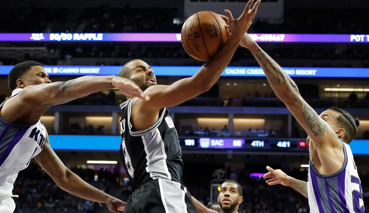 Pemain Sacramento Kings berusaha menghadang pergerakan pemain San Antonio Spurs, Tony Parker (tengah) dalam laga reguler NBA 2016-2017 di Golden 1 Center, Sacramento, Kamis (17/11/2016) WIB. (AP Photo/Rich Pedroncelli)