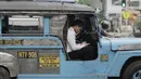 Pengemudi mobil Jeepney bermain handphone saat berada di Manila, Filipina, Jumat (22/11). Jeepney merupakan transportasi umum paling populer dan sudah menjadi ikon di Filipina. (Bola.com/M Iqbal Ichsan)