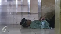 Seorang lelaki tidur di pelataran Masjid Istiqlal, Jakarta, Selasa (7/6). Beragam kegiatan dilakukan sejumlah warga untuk menunggu waktu berbuka puasa. (Liputan6.com/Immanuel Antonius)