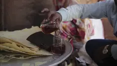 Seorang pria Sudan menuangkan segelas "helo-murr", minuman khas Ramadhan yang terbuat dari jagung kering dan rempah-rempah yang kemudian dicelupkan ke dalam air, di Khartoum, Sudan, pada 22 Maret 2023. (AP Photo/Marwan Ali)