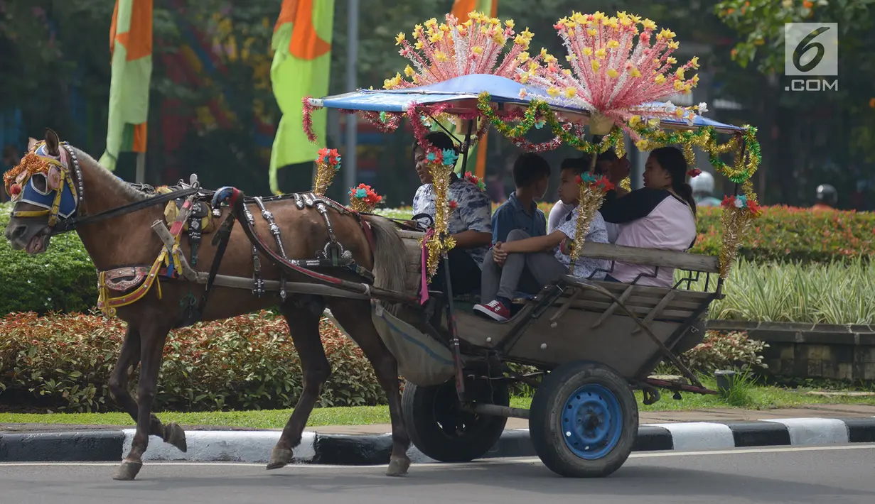 Pengunjung berkeliling naik delman hias di Monumen Nasional (Monas), Jakarta, Sabtu (15/6/2019). Sebelumnya delman hias tersebut dilarang kini beroperasi kembali, delman tersebut mengenakan tarif pada pengunjung bervariasi untuk berkeliling di luar IRTI Monas. (merdeka.com/Imam Buhori)