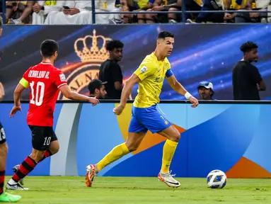 Pemain Al Nassr, Cristiano Ronaldo (kanan), mengontrol bola dibayangi pemain Istiklol dalam laga kedua Grup E Liga Champions Asia 2023/2024 yang berlangsung di Al Awal Park at King Saud University, Riyadh, Selasa (3/10/2023) dini hari WIB. (AFP/Fayez Nureldine)