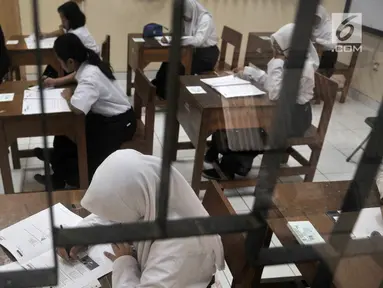 Siswa Sekolah Menengah Pertama Luar Biasa (SMPLB) Kategori B atau tunarungu saat mengerjakan Ujian Nasional Kertas Pensil (UNKP) di SLB Negeri 7 Jakarta, Selasa (24/4). UNKP di SLB tersebut diikuti oleh delapan peserta. (Merdeka.com/Iqbal Nugroho)