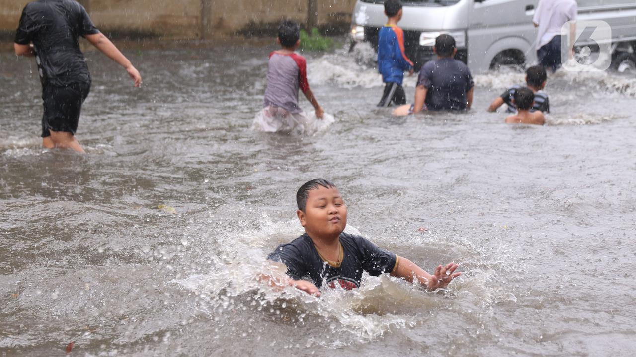 Meski Berbahaya, Banjir Jadi Lahan Favorit Anak-Anak Bermain Air
