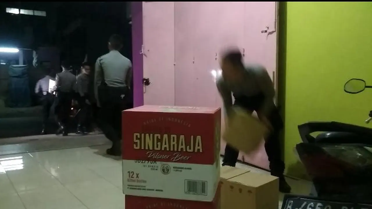 Petugas tengah memindahkan ribuan botol miras dalam ratusan dus siap edar di rumah janda di Garut