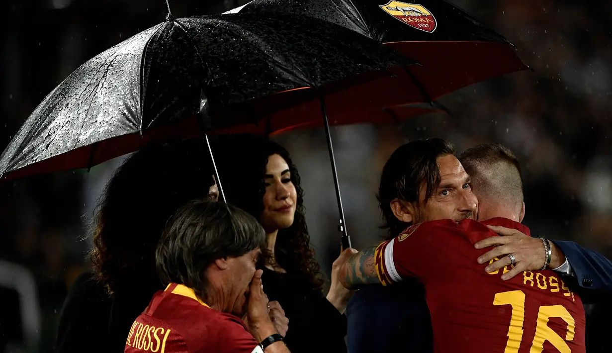 Gelandang AS Roma, Daniele De Rossi, bersama Francesco Totti usai melawan Parma pada laga Serie A di Stadion Olympic, Roma, Minggu (26/5). Laga ini perpisahan bagi De Rossi dan AS Roma setelah 18 tahun. (AFP/Filippo Monteforte)