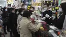 Warga menerima masker wajah gratis dalam sebuah toko kosmetik di Tsuen Wan, Hong Kong, Selasa (28/1/2020). Hong Kong terkonfirmasi memiliki delapan kasus infeksi virus corona. (AP Photo/Achmad Ibrahim)