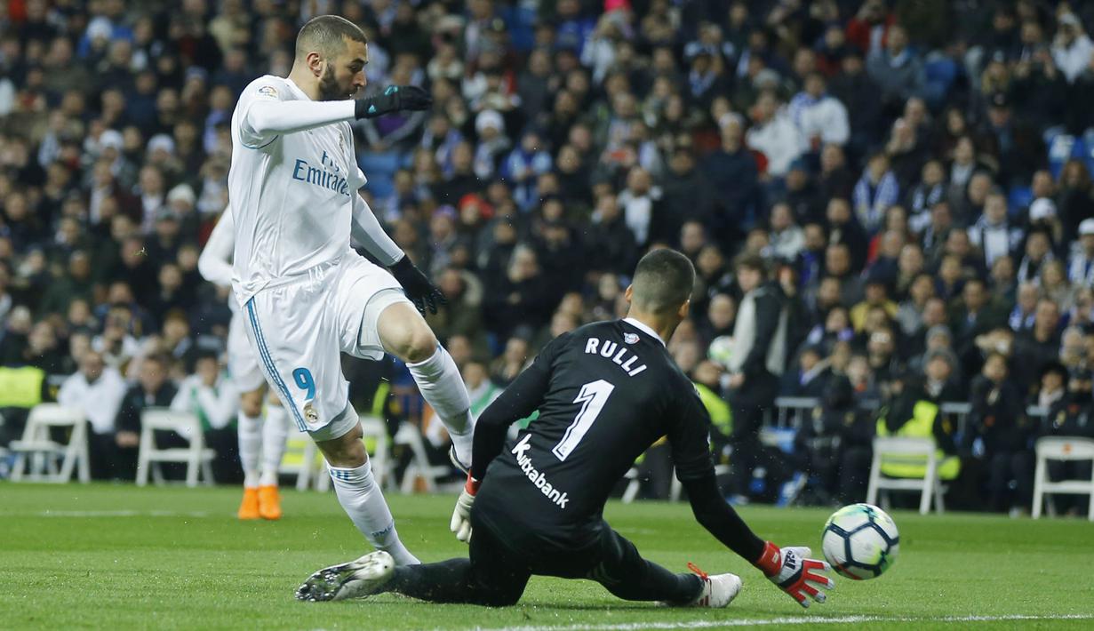 Striker Real Madrid, Karim Benzema, berusaha melewati kiper Real Sociedad, Geronimo Rulli, pada laga La Liga di Stadion Santiago Bernabeu, Sabtu (10/2/2018). Real Madrid menang 5-2 atas Real Sociedad. (AP/Francisco Seco)