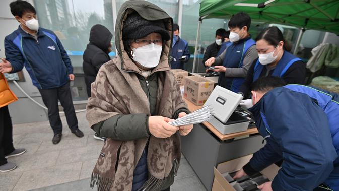 Seorang wanita membeli masker di supermarket di Seoul, Korea Selatan, Rabu (4/3/2020). Kasus virus corona atau COVID-19 di Korea Selatan menjadi yang terbesar setelah China, negara asal wabah virus tersebut. (Jung Yeon-je/AFP)