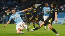 Pemain Manchester City Phil Foden (kiri) berebut bola dengan pemain Arsenal pada laga Premier League di Etihad Stadium, Manchester, Inggris, Rabu (17/6/2020). Manchester City menang dengan skor 3-0. (PETER POWELL/POOL/AFP)