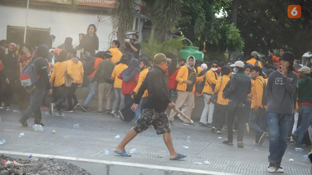 Pria berbaju hitam dengan masker oranye membawa parang di tengah aksi demo di Makassar (Liputan6.com/Fauzan)