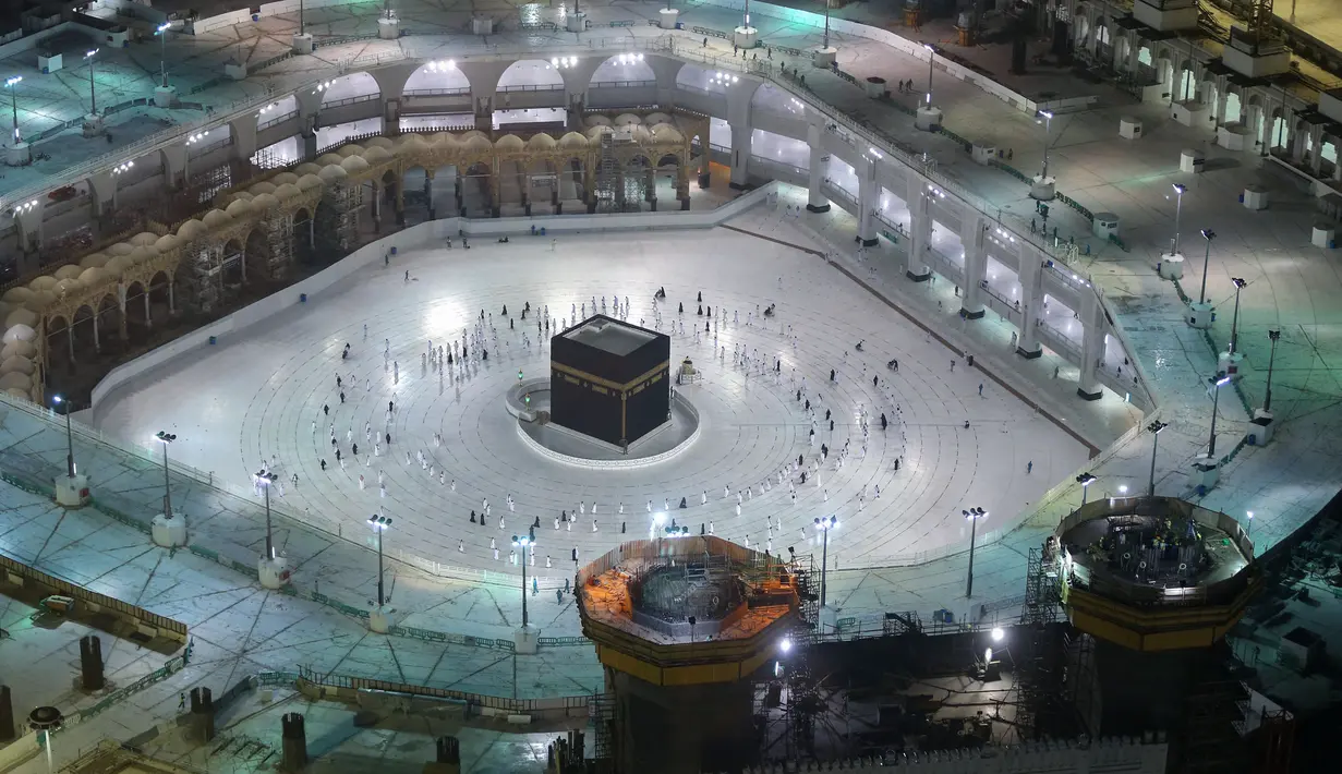 Warga Saudi dan warga asing mengelilingi Ka'bah (tawaf) saat melaksanakan umrah di kompleks Masjidil Haram, kota suci Makkah, Minggu (4/10/2020). Arab Saudi mengizinkan kembali ibadah umrah usai peringanan pembatasan sosial dan karantina wilayah di tengah pandemi Covid-19 di Tanah Suci. (AFP)
