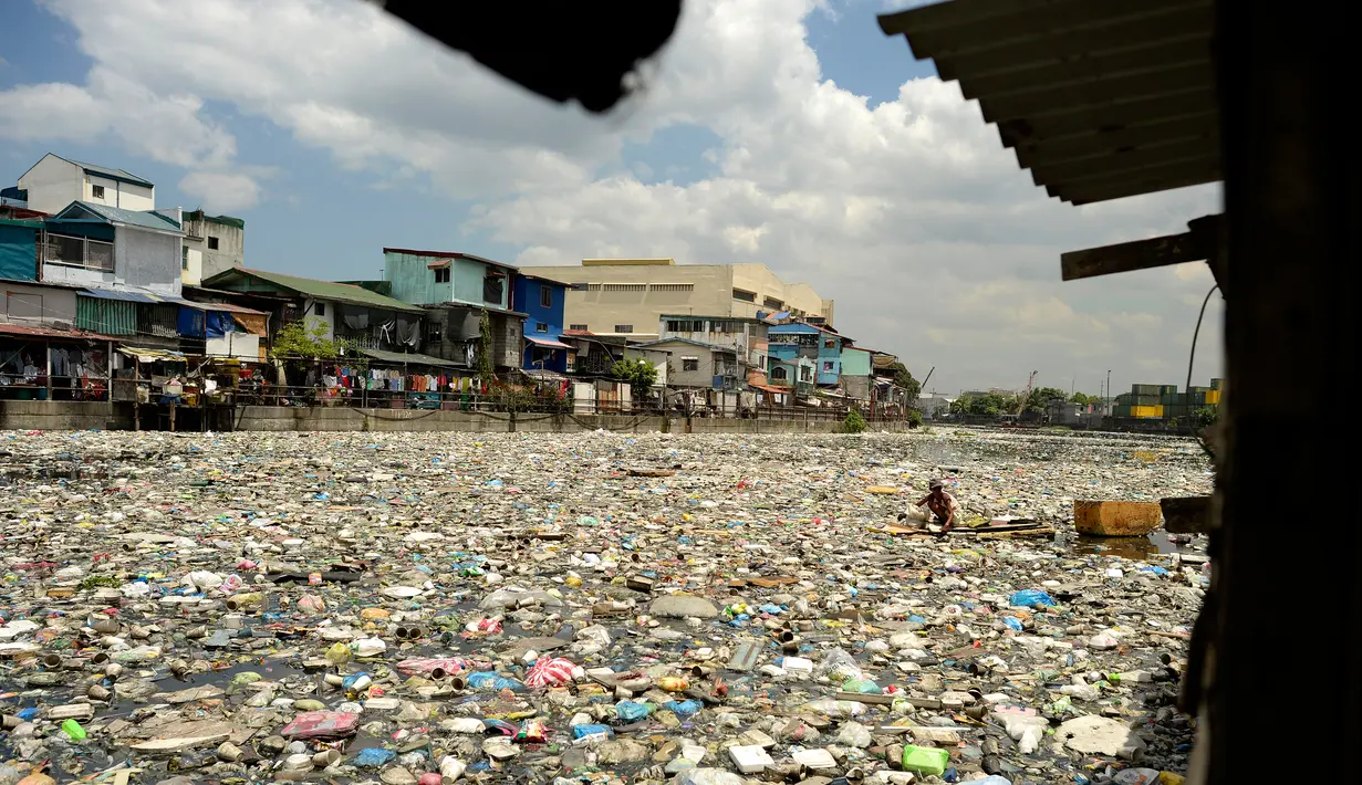 Teresita Gapayao (51) diantara tumpukan sampah di aliran Sungai Estero de Vitas di Tondo, Manila, Filipina, Kamis (21/4). Teresita sudah 12 tahun menafkahi keluarganya dari sampah-sampah yang bisa di daur ulang. (Noel CELIS/AFP)