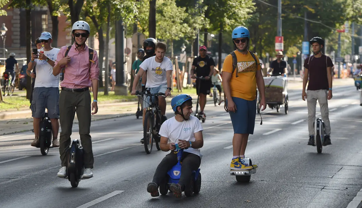 Sejumlah orang mengikuti parade kendaraan listrik di Wina, Austria, 13 September 2020. Ratusan kendaraan listrik ambil bagian dalam parade E-Mobility "Rock the Ring" untuk mempromosikan mobilitas bebas emisi dan ramah iklim. (Xinhua/Guo Chen)