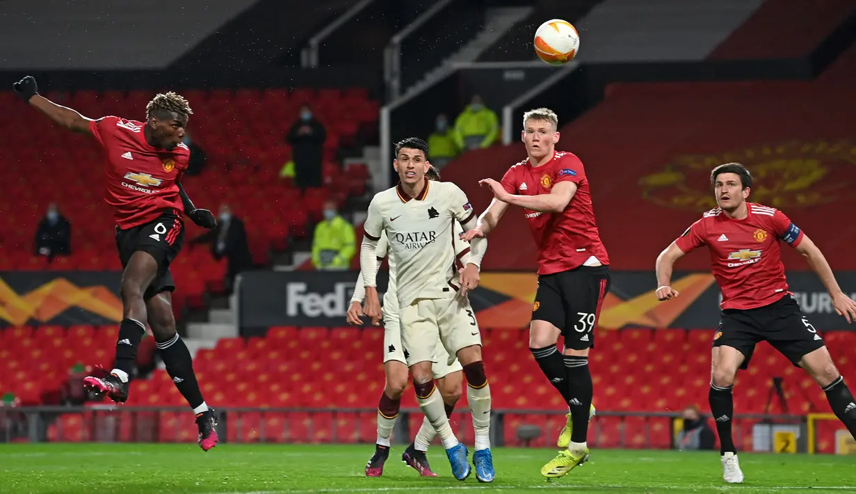 Gelandang Manchester United, Paul Pogba (kiri) melepaskan sundulan yang berbuah gol kelima timnya ke gawang AS Roma dalam laga leg pertama semifinal Liga Europa 2020/2021 di Old Trafford Stadium, Manchester, Kamis (29/4/2021). Manchester United menang 6-2 atas AS Roma. (AFP/Paul Ellis)